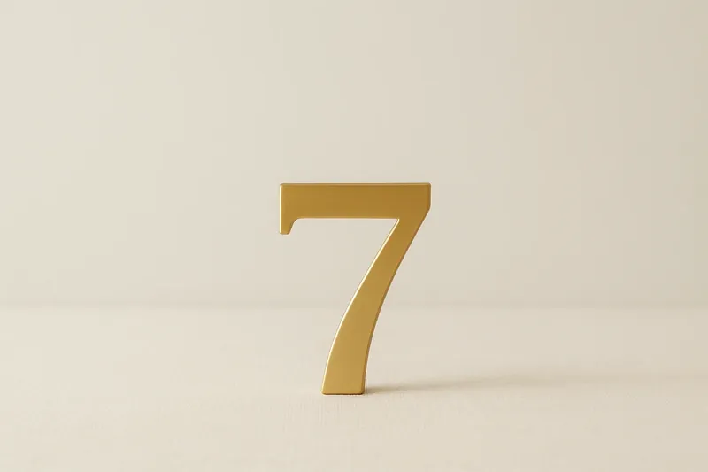 Large golden seven symbol on cream background with soft shadow
